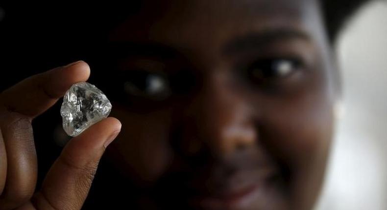 A visitor holds a diamond during a visit to the De Beers Global Sightholder Sales (GSS) in the capital Gaborone in Botswana, November 24, 2015. 