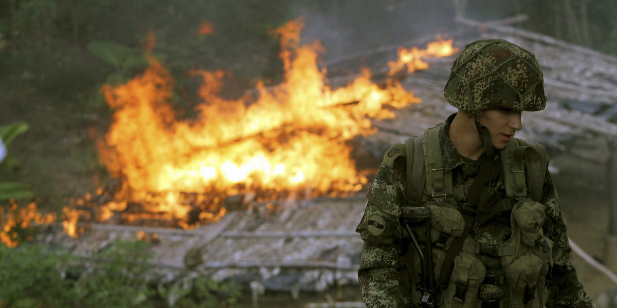 A soldier from the Seventh Division of the Colombian National Army in front of a shack that served as a make-shift cocaine laboratory, after members of the unit burned it down during an operation to eradicate coca plants at a plantation in Yali, northeastern Antioquia, Colombia, September 3, 2014.