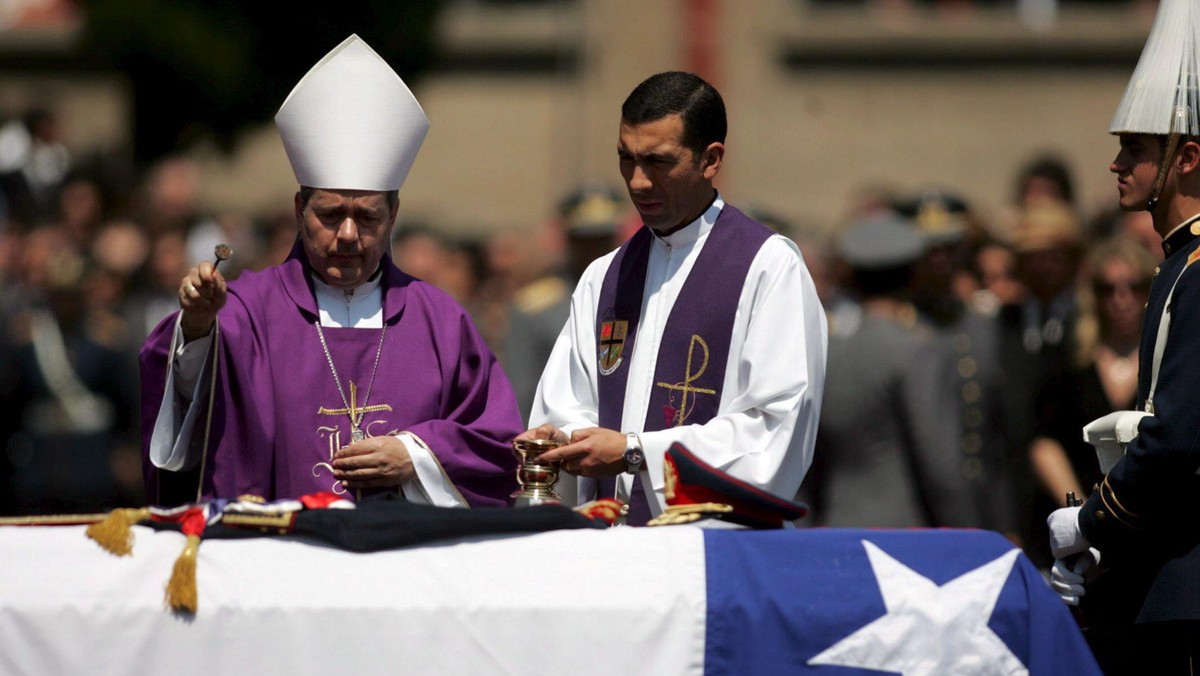 Biskup polowy Juan Barros Madrid (L) błogosławi trumnę ze zwłokami byłego dyktatora Chile Augusto Pinocheta 