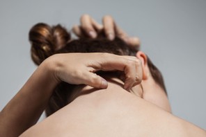 Portrait from behind of woman scratching