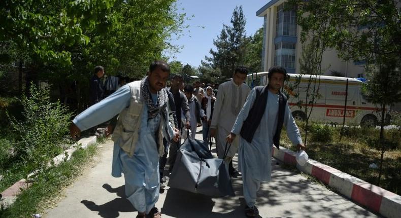 Afghan volunteers carry the body of a Kabul resident killed in a car bomb attack in May