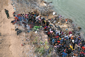 MONITORING Asylum seekers supervised by border control agents who cut wire to allow entry to Texas for processing.