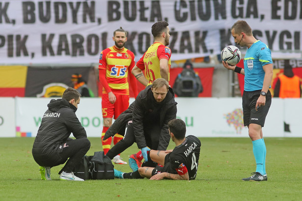 Piłkarz Cracovii Sergiu Hanca leży na murawie podczas meczu Ekstraklasy z Jagiellonią Białystok