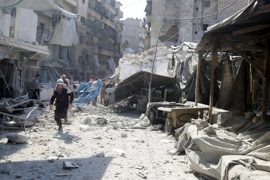 A civil defence member runs at a market hit by air strikes in Aleppo's rebel-held al-Fardous district.