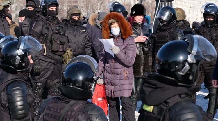 Beszédet mondó tüntető Habarovszkban január 23-án, körülötte rohamrendőrök.