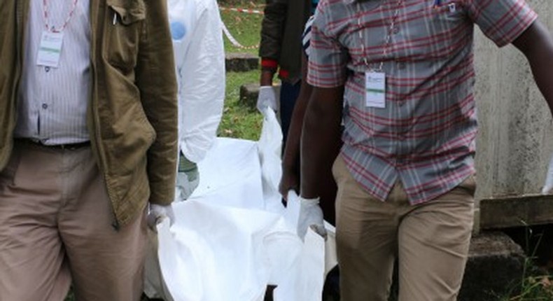 Police carrying a dead body from a crime scene