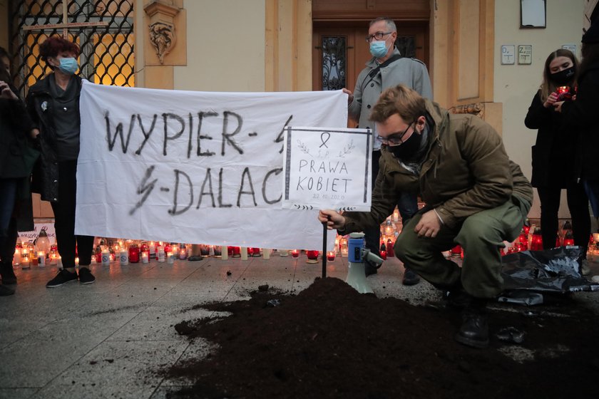 Znicze i ziemia wysypana przed siedzibą PiS