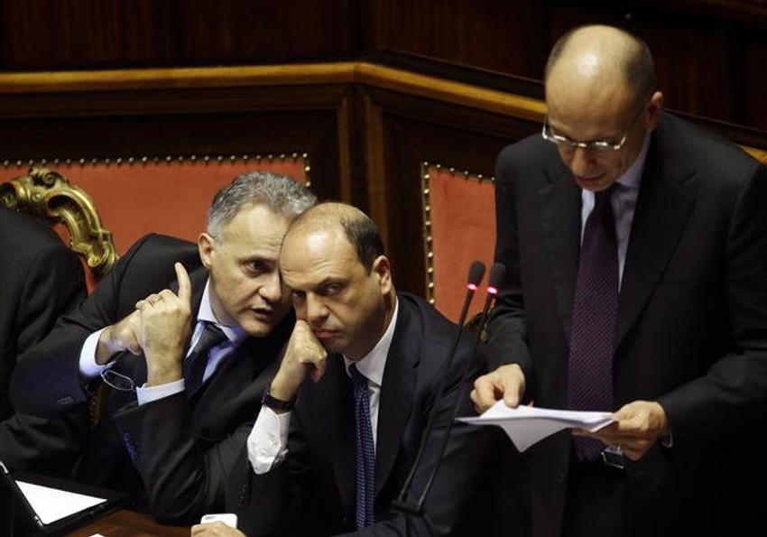 Italijanski ministar odbrane Mario Mauro (L) priča sa ministrom unutrašnjim poslova Anđeliniom Afanom, dok premijer Enriko Leta drži govor uoči glasanja