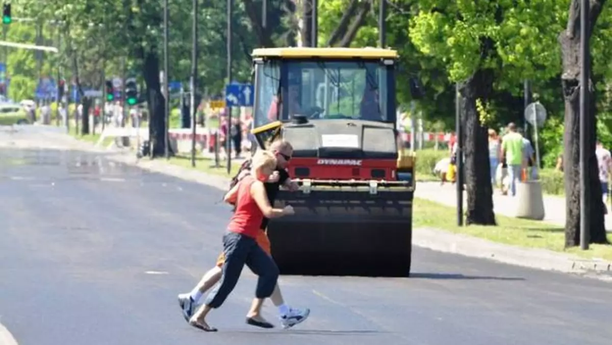 Piesi idą po gorący asfalcie