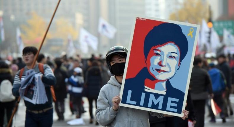 A protester holds a placard with a portrait of South Korea's President Park Geun-Hye, during an anti-government rally in Seoul