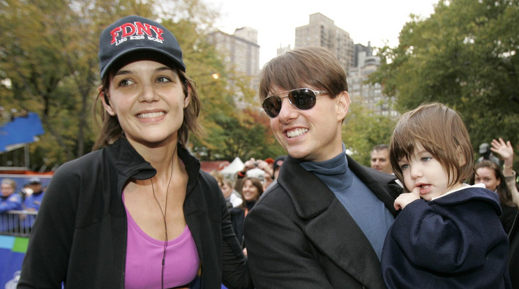 Katie Holmes színésznő csatlakozik férjéhez, Tom Cruise-hoz, aki kezében tartja lányukat, Surit, miután Holmes befejezte a New York-i maratont