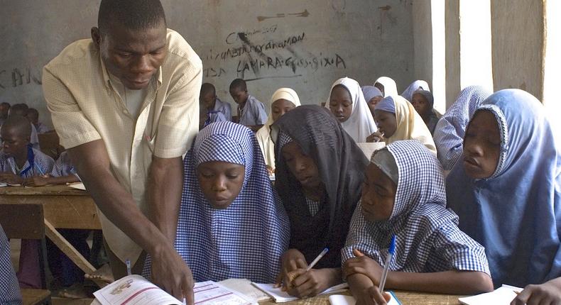 Primary school teacher and pupils in a Nigerian classsroom 