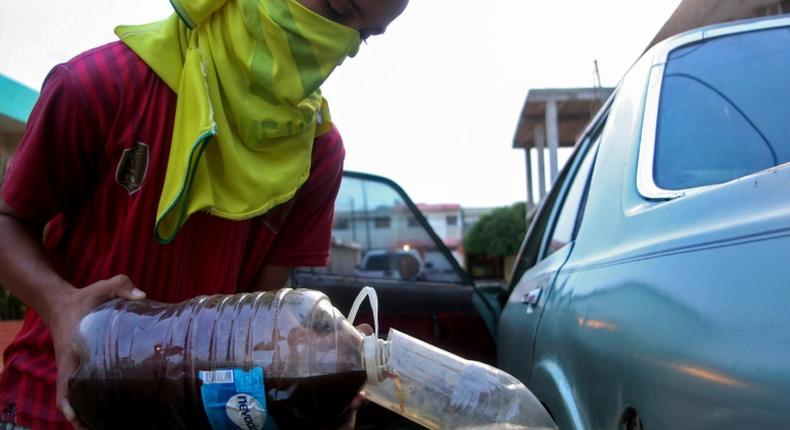 A youngster fills a car with gasoline purchased on the streets in Maracaibo, Venezuela, in August 2020