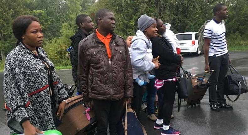 Asylum seekers who are steps away from Canada listen as the Royal Canadian Mounted Police tells them they will be arrested as they cross over from New York state, north of Plattsburgh