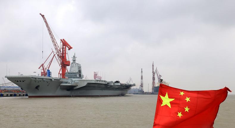 China's third aircraft carrier, the Fujian, docks in Shanghai with a Chinese flag seen in the foreground.Pu Haiyang/Xinhua via Getty Images