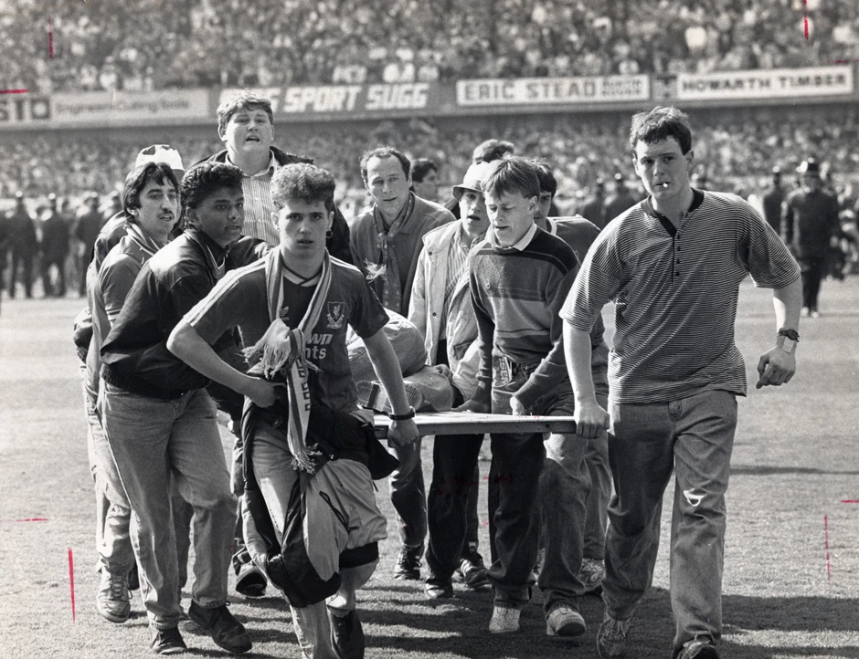 Navijači nose jednog od povređenih nakon tragedije na stadionu Hilsboro