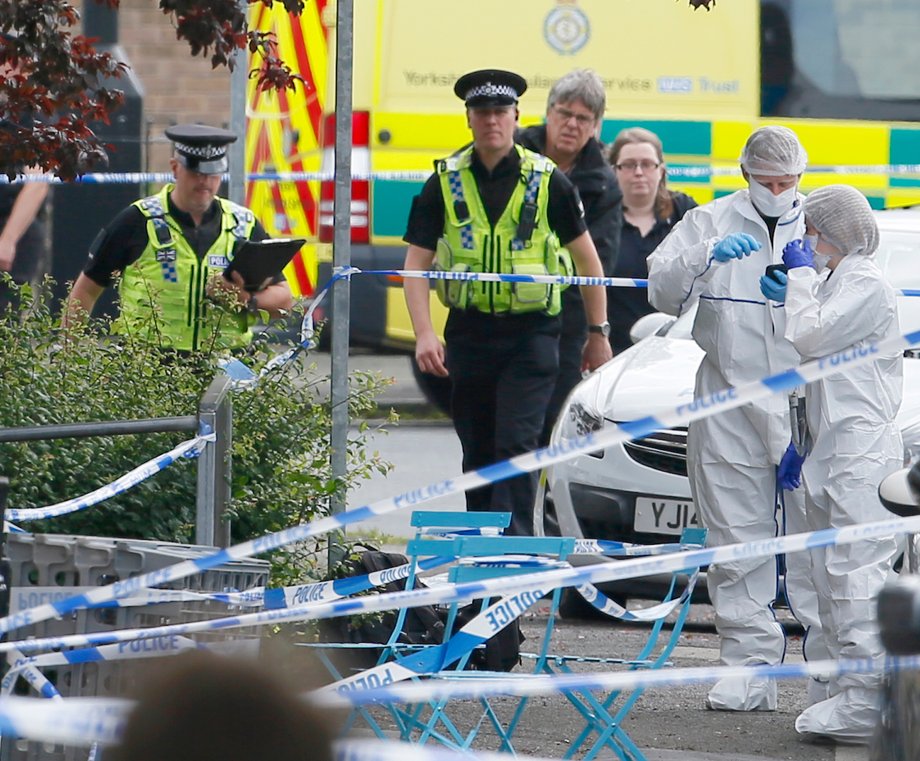 Police and forensics investigators stand behind a cordon in Birstall near Leeds, June 16, 2016.