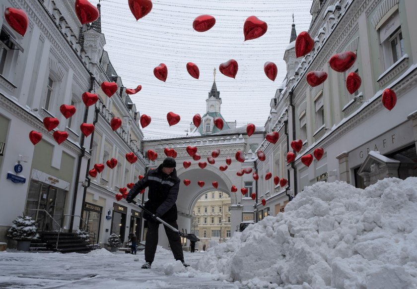 Workers remove snow in a street in Moscow