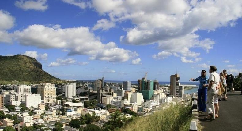 A tour guide stands with a group of tourists at a viewpoint overlooking Port Louis in a file photo. REUTERS/Ed Harris