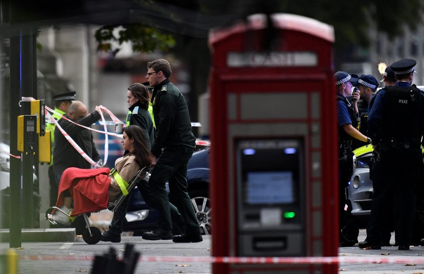 Emergency services personnel wheel a woman in a wheelchair to a nearby ambulance near the Natural Hi