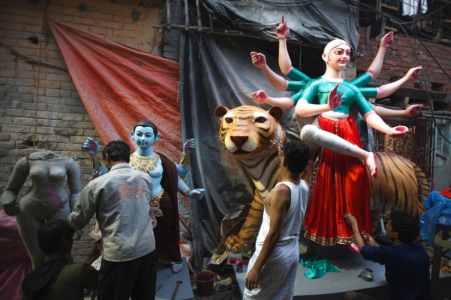 Rzeźbiarze w Kalkucie ozdabiają glinianą rzeźbę Durgi na święto Durga Pudźa