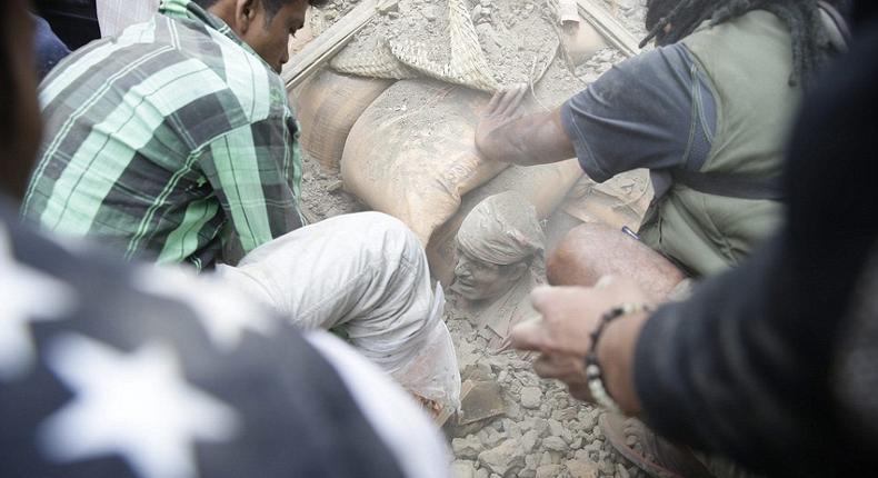 A man is buried up to his neck in rubble as the rescue teams attempt to dig him free from the collapsed building in the capital of Nepal.