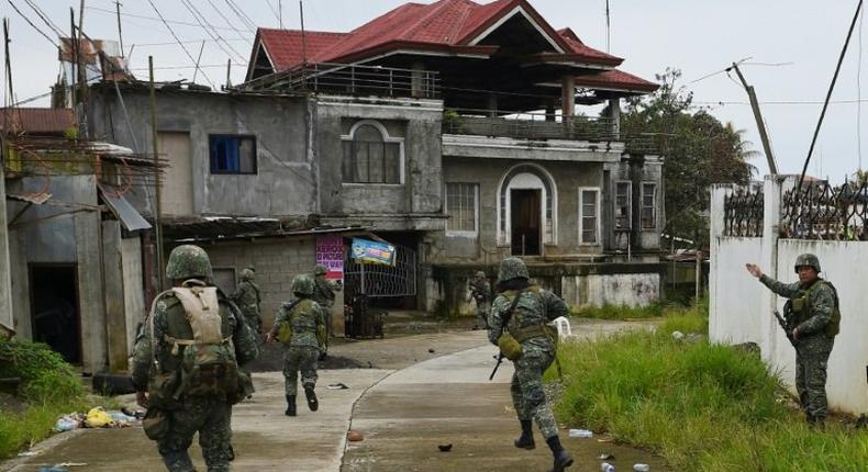 Philippine Marines taking cover from sniper fire while on patrol at the frontline in Marawi on the southern island of Mindanao