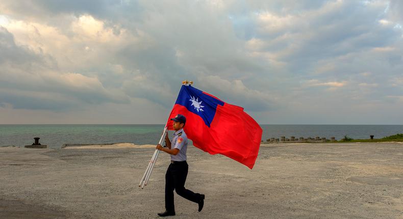 A Taiwanese coast guard personnel carrying some roc flags after a flag raising ceremony was held near the sea shore of Pratas Island.Alberto Buzzola/LightRocket via Getty Images