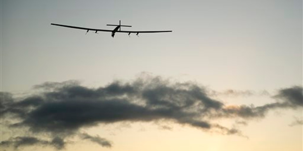 The Solar Impulse 2 solar plane flies into the sunrise out of Kalaeloa Airport, Thursday, April 21, 2016, in Kapolei, Hawaii. The solar plane will fly a two-and-a-half day journey to Northern California. (AP Photo/Marco Garcia)