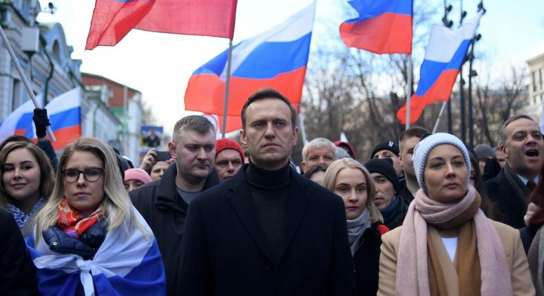 Russian opposition leader Alexei Navalny and his wife Yulia walk with demonstrators during a 2020 march in memory of murdered Kremlin critic Boris Nemtsov in downtown Moscow. He suffered a life-threatening poisoning months later, in August 2020. [KIRILL KUDRYAVTSEV/AFP via Getty Images]