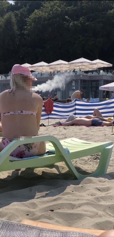 Kobieta paląca na plaży papierosa