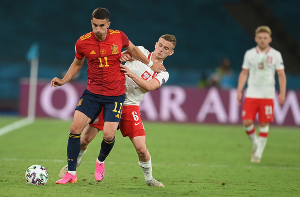 Ferran Torres (L) w starciu z Kacprem Kozłowskim (P) podczas meczu Polski z Hiszpanią