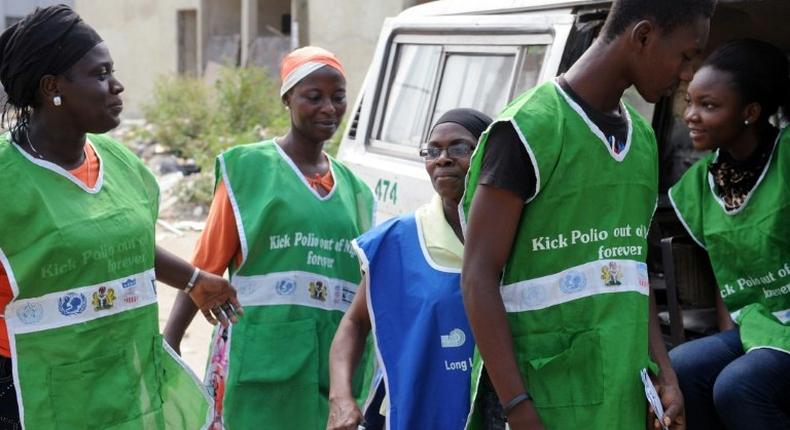 Health workers try to board a vehicle taking them to designated centres to immunise children.