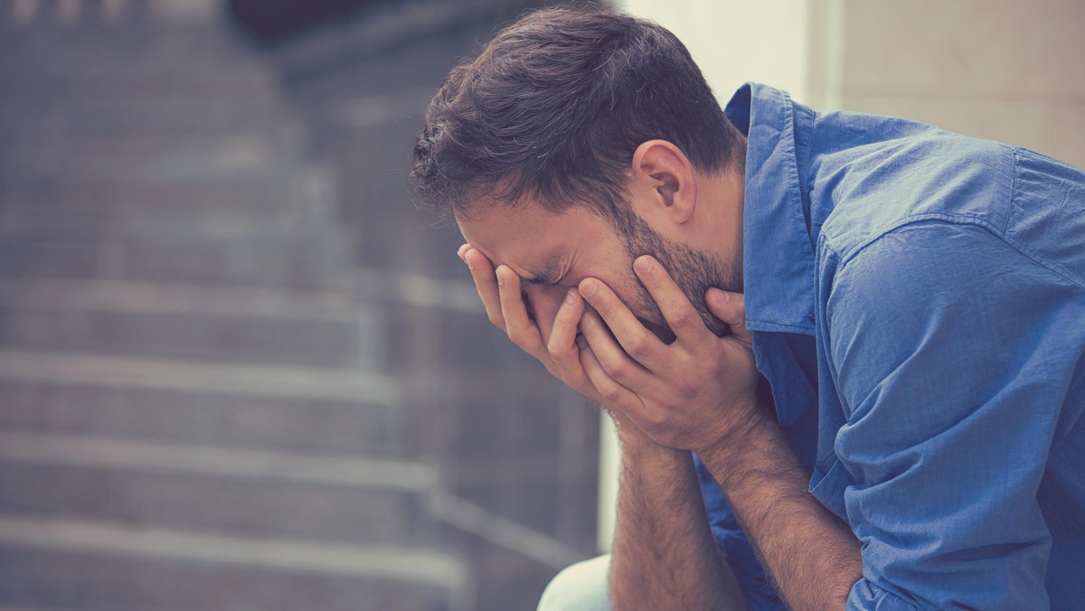 stressed sad crying man sitting outside