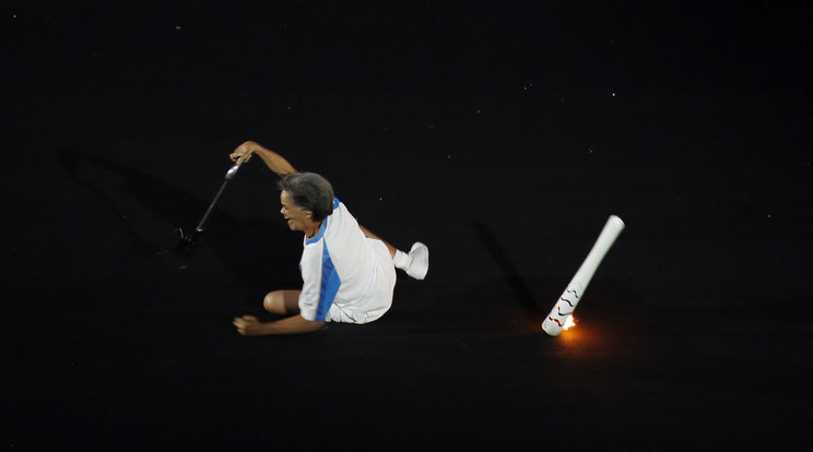 A dél-amerikai parasportoló próbál felállni, miután elesett és elejtette az olimpiai lángot /Fotó: MTI/AP/Silvia Izquierdo