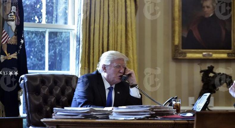 President Donald Trump speaks on the phone with Russia's President Vladimir Putin from the Oval Office of the White House on January 28, 2017, in Washington. 