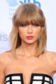 Taylor Swift tömött szőke frufruja és hozzá vállig érő hajhossza remek választás bármilyen arcformához.