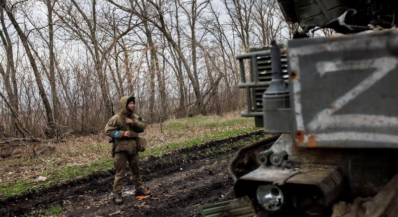 A Ukrainian soldier stands next to a destroyed Russian anti-aircraft missile system in the village of Husarivka on April 14, 2022.