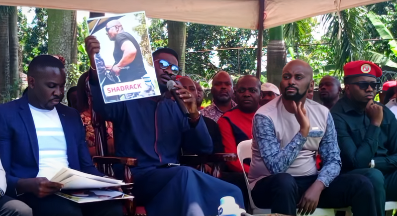 Bobi WIne displays a photo of one of the police officers involved in the Tuesday incident