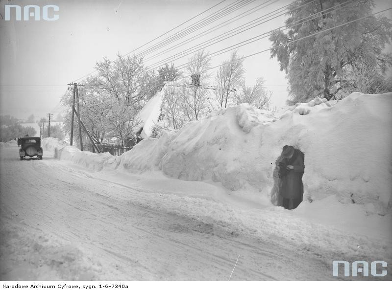 Droga przez wieś. Na zdjęciu widoczny mężczyzna stojący w miejscu wykopanym w zaspie śnieżnej. 1929 rok.
