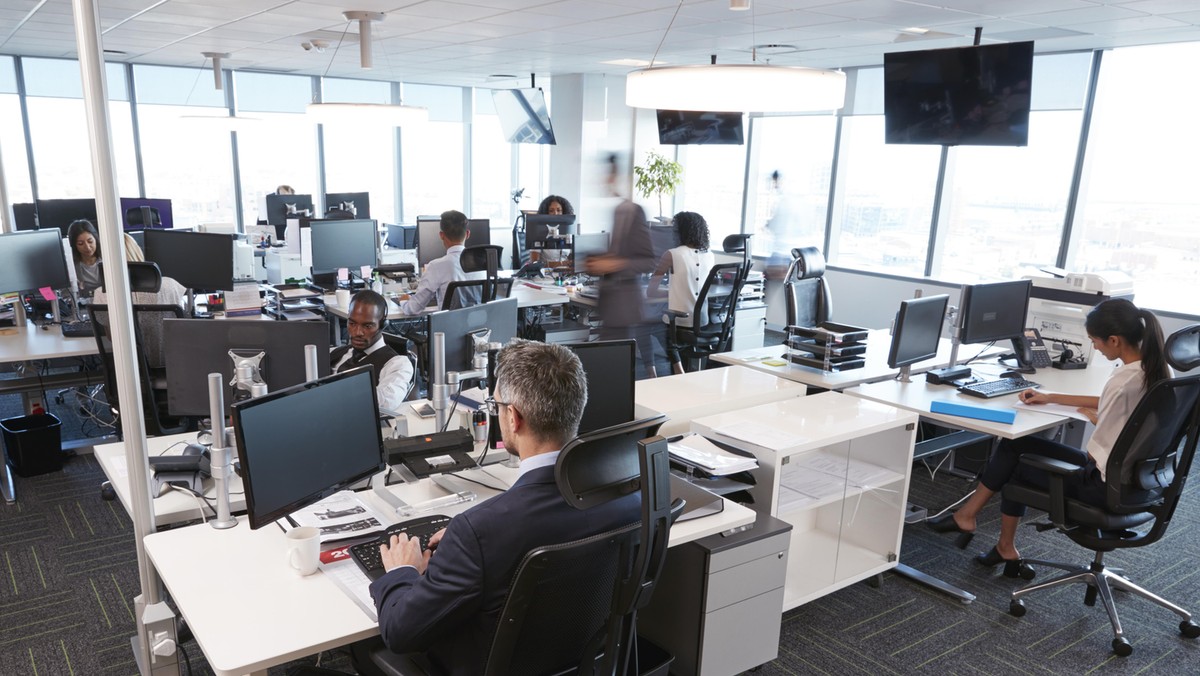 Interior Of Busy Modern Open Plan Office With Staff