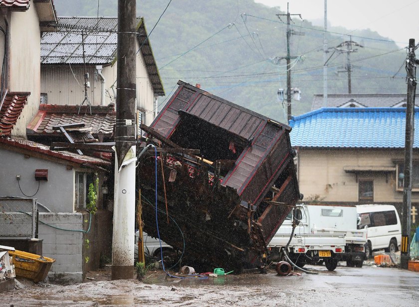 A car is pictured after it was drifted by torrential rain in Hitoyoshi