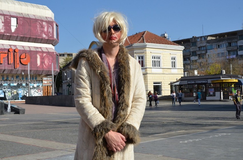 Novi performans u Prijedoru: Muškarac obučen kao žena stoji na trgu