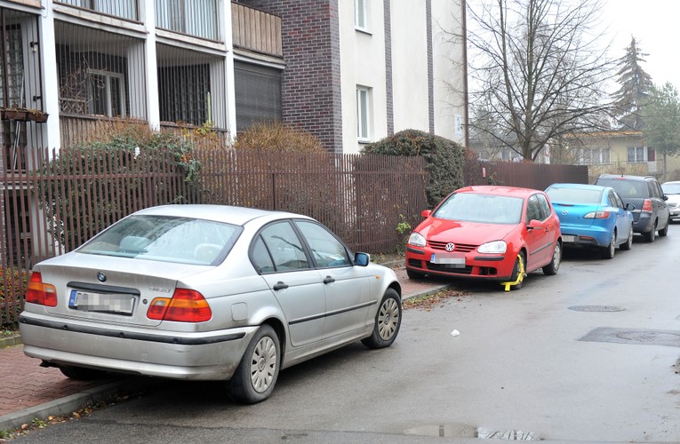 Źle zaparkowane samochody na ulicy Turystycznej w Krakowie. Wśród nich volkswagen golf prezydenta Andrzeja Dudy