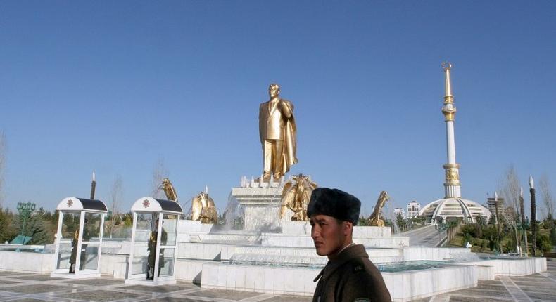 Soldiers stand guard near a golden statue of Turkmenistan's first president Saparmurat Niyazov in the capital Ashgabat