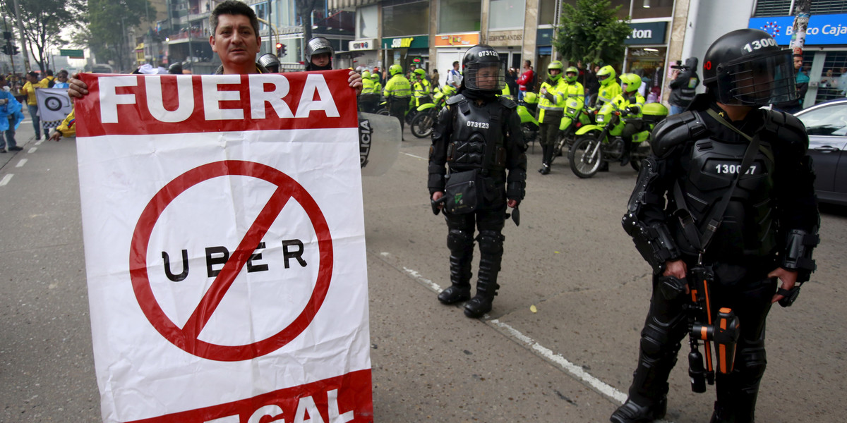 Cab drivers blocked an avenue to protest against the Uber ride-hailing service in Bogota, Colombia, on March 14. The sign reads, "Out, Uber illegal."