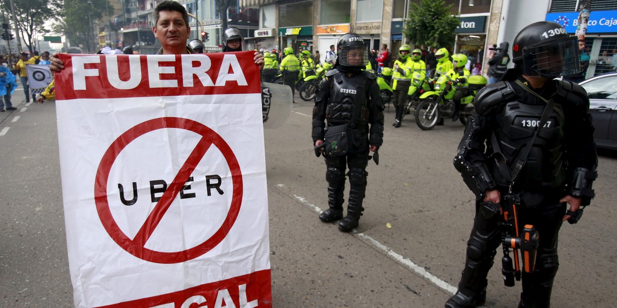 Cab drivers blocked an avenue to protest against the Uber ride-hailing service in Bogota, Colombia, on March 14. The sign reads, "Out, Uber illegal."