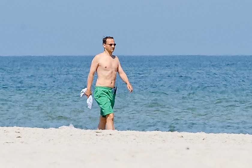 Radosław Sikorski na plaży ćwiczy brzuszki 