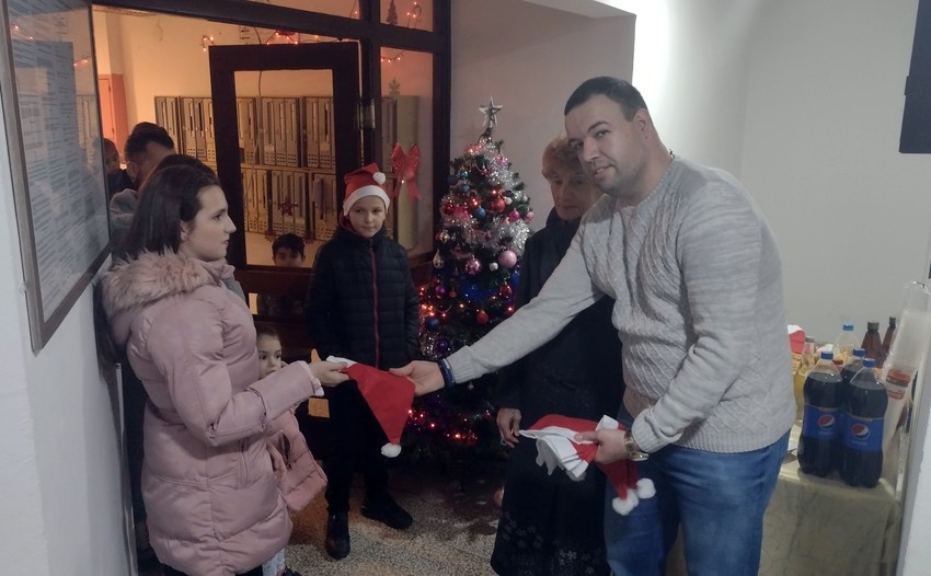 Upravnik zgrade Miloš Stefanović deli novogodišnje kape deci i komšijama iz zgrade u Ulici generala Milojka Lešjanina 65 