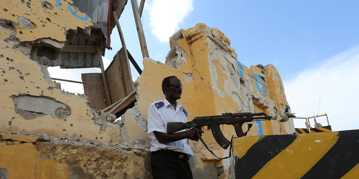 A Somali traffic policeman stands guard near the scene of a suicide car bomb explosion outside the traffic police headquarters in Somalia's capital Mogadishu May 9, 2016.